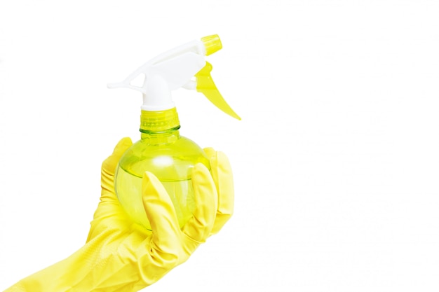 Hand in yellow rubber glove holding plastic spray. Isolated on white