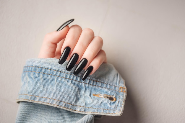 Hand of a young girl with black manicure on nails