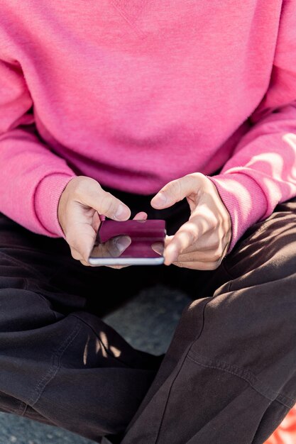 Hand of a young man using mobile phone