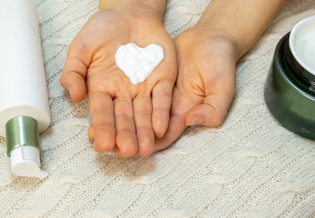 Photo the hand of a young woman takes a face cream from the jar. skin care, hydration and nutrition.