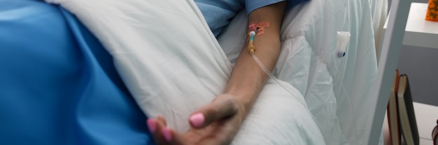 Hand of a young woman with a dropper in ward