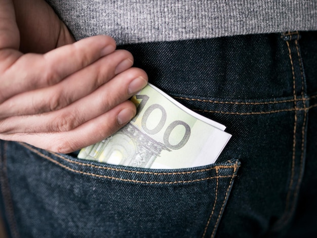 Hand zet Euro in jeans zak