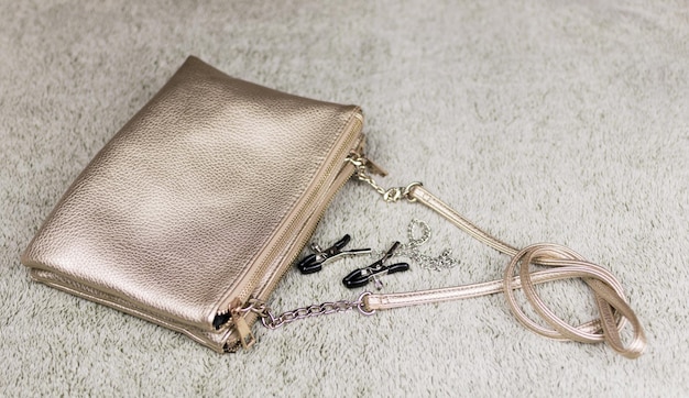 Handbag of a woman who loves BDSM sex Dropped from the bag clamps for the nipples