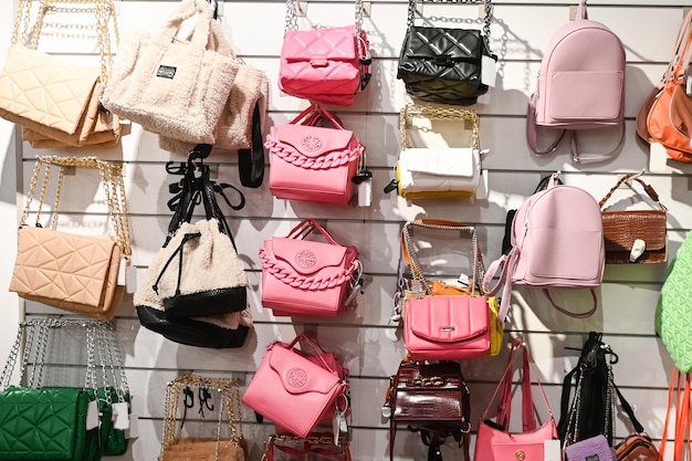 Photo handbags of different colors hang on the window in the store