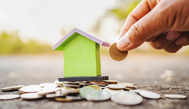 Handbesparingsgeld met minihuis en muntstukkenstapel