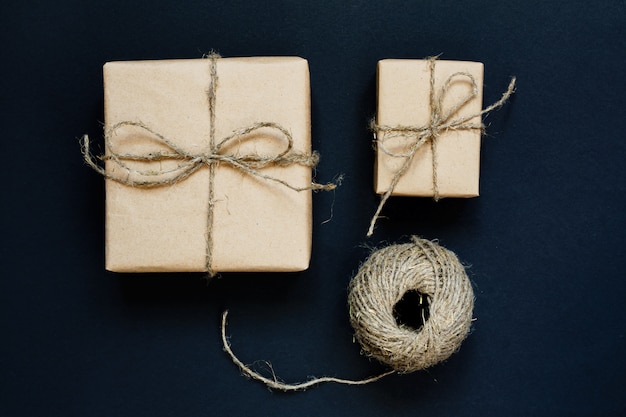 Handcrafted gift box wrapped in Craft paper with rope and bow on black