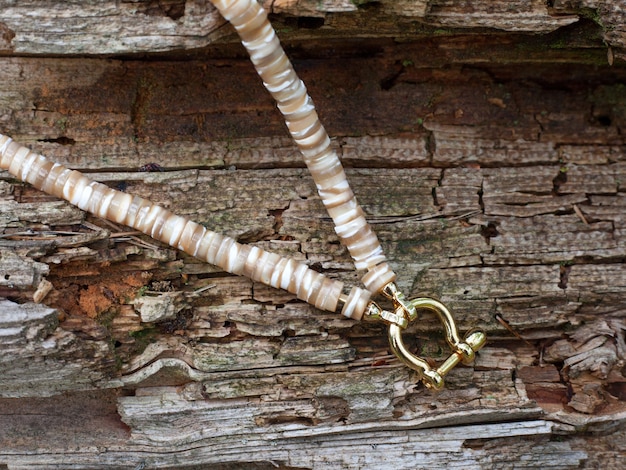 木製の背景に女性への贈り物として磨かれた部分から真珠のネックレスの手作りの母
