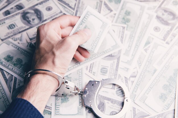 Handcuffed man holding money