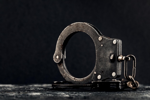 Photo handcuffs on a dark background the concept of crime and police