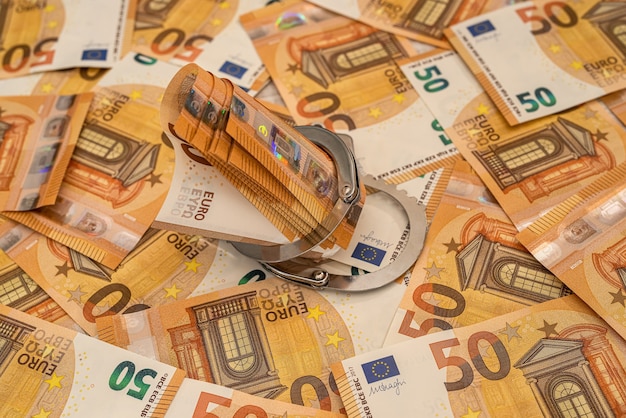 手錠とユーロ紙幣。汚職と贈収賄の概念