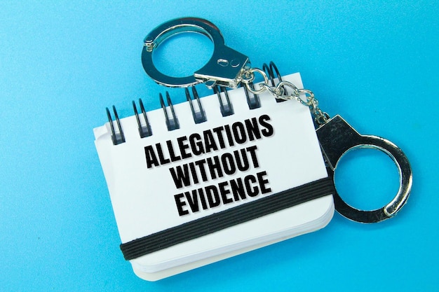 Handcuffs and white papers with patches of allegations without evidence