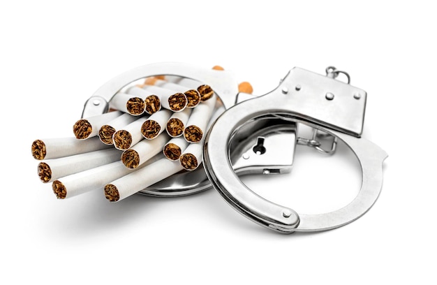 Photo handcuffs with cigarettes on white