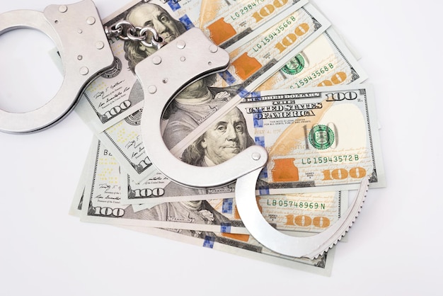 Handcuffs with dollars on a white background