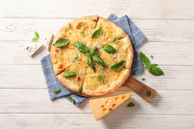 Handdoek, board, kaas pizza met basilicum op houten achtergrond