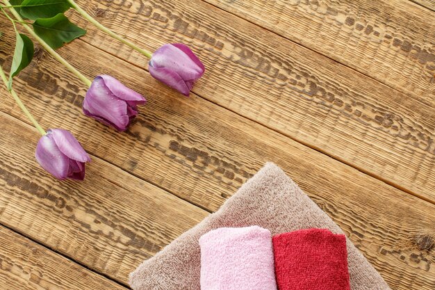 Handdoeken en lila tulp bloemen op houten achtergrond