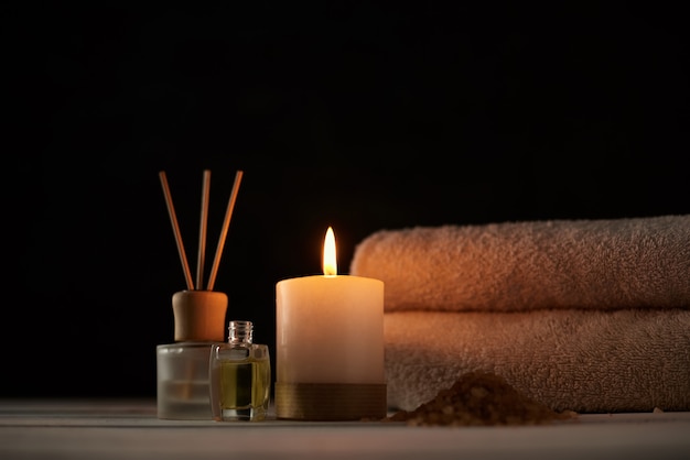 Handdoeken, kaars en massage olie op witte tafel
