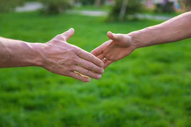 Handdruk van mannen tijdens een bijeenkomst in het park Selectieve focus