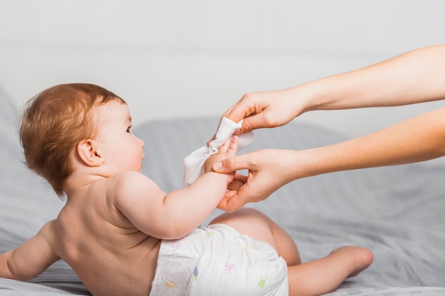 Handen die baby met baby schoonmaken afvegen