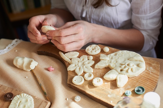 Handen die een handgemaakt product maken van deeg