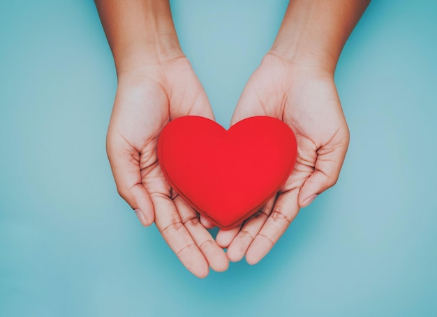 Handen die een rood hart houden gezondheidszorg liefde wereld hart dag wereld gezondheidsdag