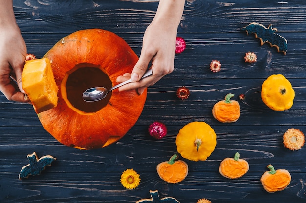 Handen die Halloween-pompoen openen op vieren houten tafel Trick or Treat horizontale weergave van bovenaf