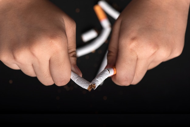 Foto handen die sigaret breken voor stoppen met roken