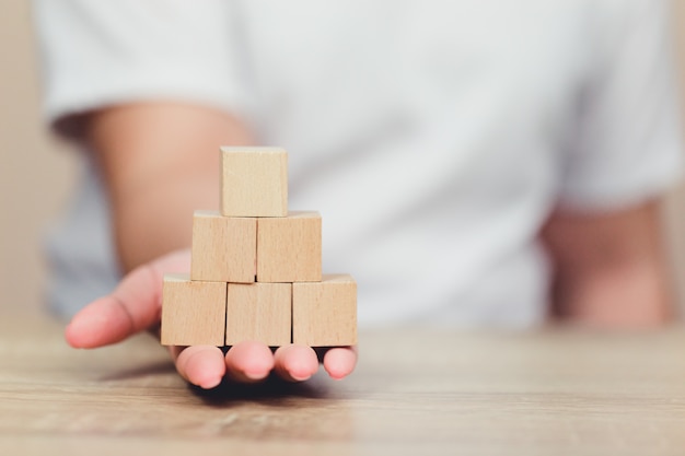 Handen die van vrouwen, houten blokken stapelen in stappen.