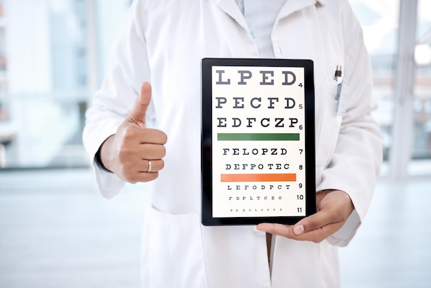 Handen duimen omhoog tabletscherm en ooggrafiek in ziekenhuis voor zichtonderzoek in kliniek Gezondheidszorg snellen technologie of vrouw optometrist of arts met thumbsup emoji en letters voor ogentest