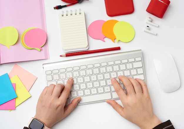 Handen en een wit toetsenbord op de werkplek van freelancers