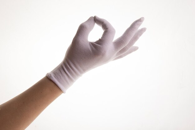 Handen gebaren in witte textielhandschoenen op een witte achtergrond