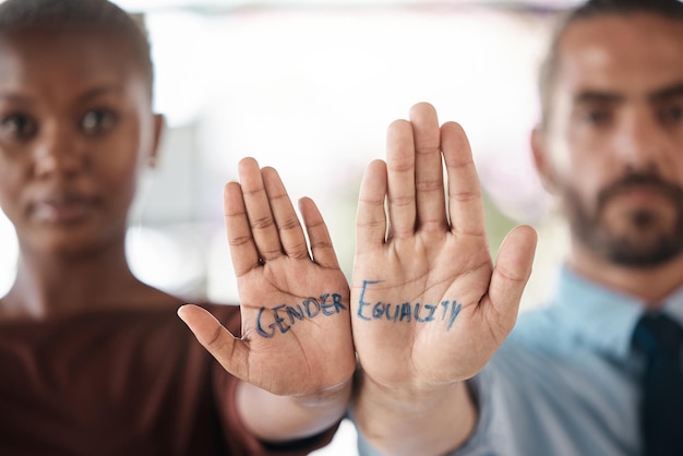 Handen gendergelijkheid en eenheid met een tekenbericht op de hand van een zakenman en -vrouw op kantoor Teamdiversiteit en empowerment met een mannelijke en vrouwelijke werknemer die solidair zijn