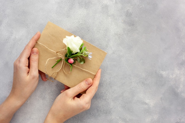 Handen houden ambachtelijke envelop met bloemen