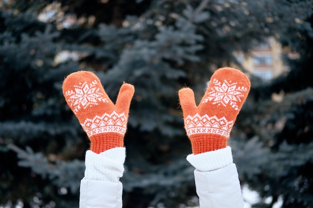 Foto handen in gebreide wanten. winter levensstijl. stijlvolle warme kleding dragen. vrouw in warme kleren