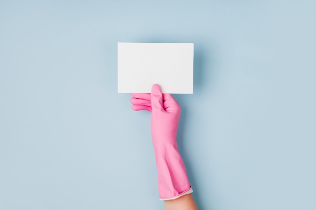 Handen in roze handschoenen houden lege kaart Schoonmaak of huishouding concept achtergrond