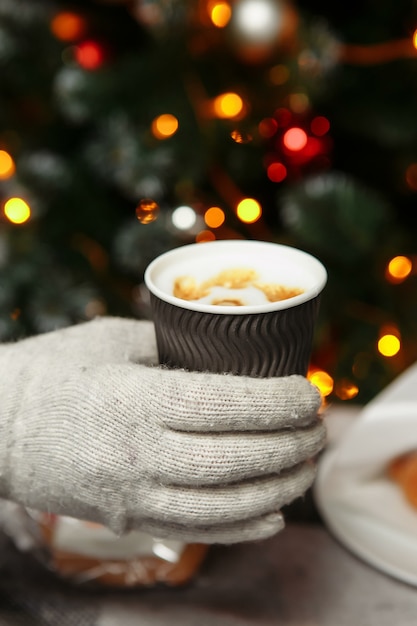 Handen in wanten houden een warme kop koffie vast. Koffie voor in de winter.