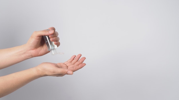 Handen is vasthouden en knijpen alcohol handgel isoalted op witte achtergrond.