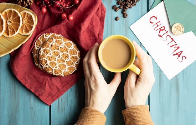 Handen, kopje cappuccino op een kersttafel ingericht