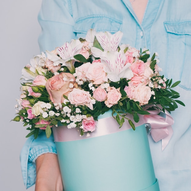 Handen met boeket van mooie bloemen. Getinte foto