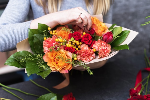 Handen met boeket van verschillende bloemen