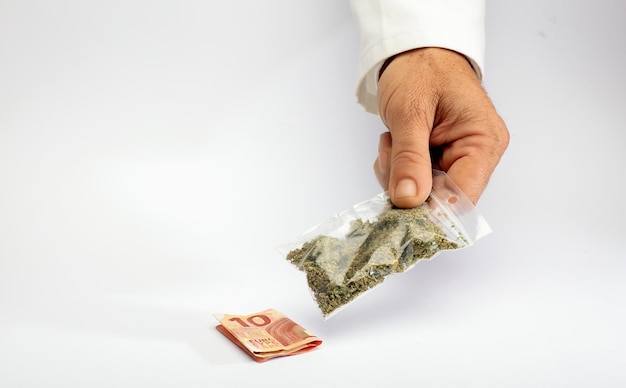 Handen met cannabistas en geld op apotheekteller Het concept van de verkoop van marihuanahennep en