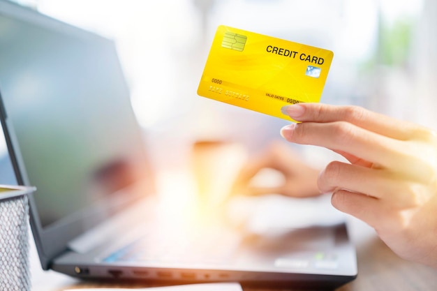 Handen met creditcard en met behulp van laptop Online winkelen e-commerce internetbankieren zakgeld werken vanuit huis concept