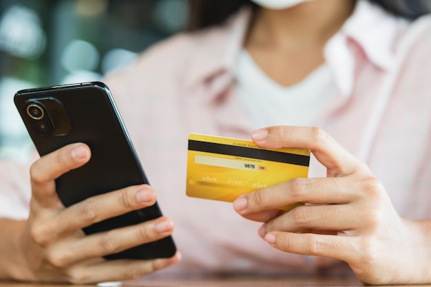 Handen met creditcard met behulp van slimme telefoon online winkelen en betalen concept