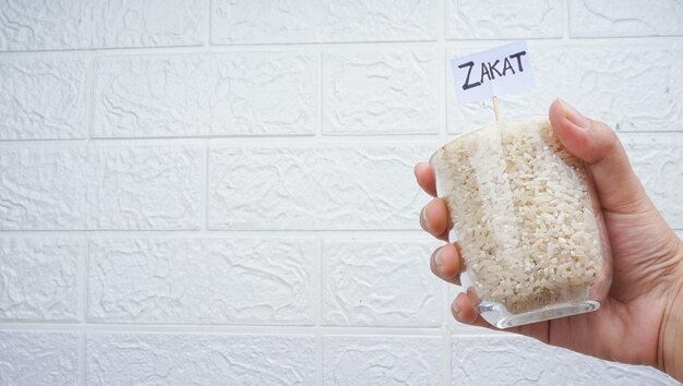 Handen met een glas rijstkorrels voor zakat Islamitisch zakat-concept