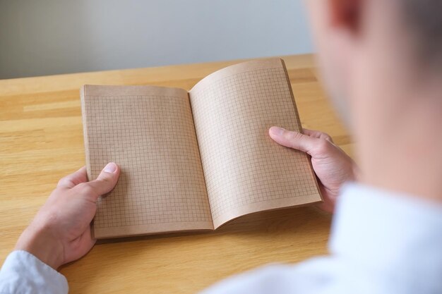 Handen met een open notitieboekje op tafel