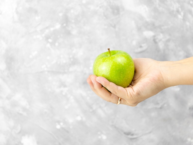 Handen met een rijpe groene appel