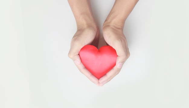 Handen met een rood hart. concepten voor donatie van hartgezondheid