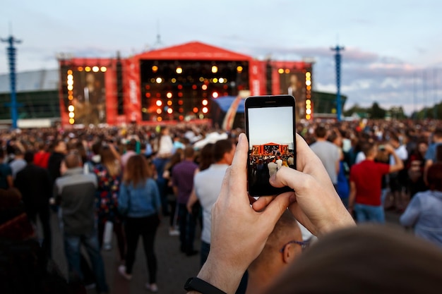 Handen met een smartphone registreert live muziekfestival live concert gelukkige jeugd