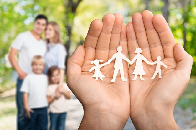 Handen met familie van papieren mensen op parkachtergrond