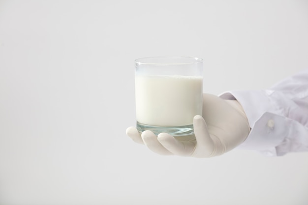 handen met handschoen met glas melk