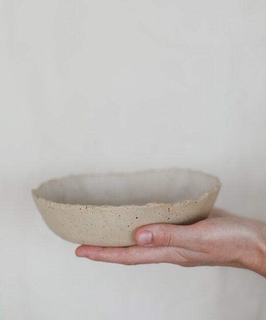 Handen met keramische kom geïsoleerd op een witte achtergrond handgemaakte keramische servies en aardewerk